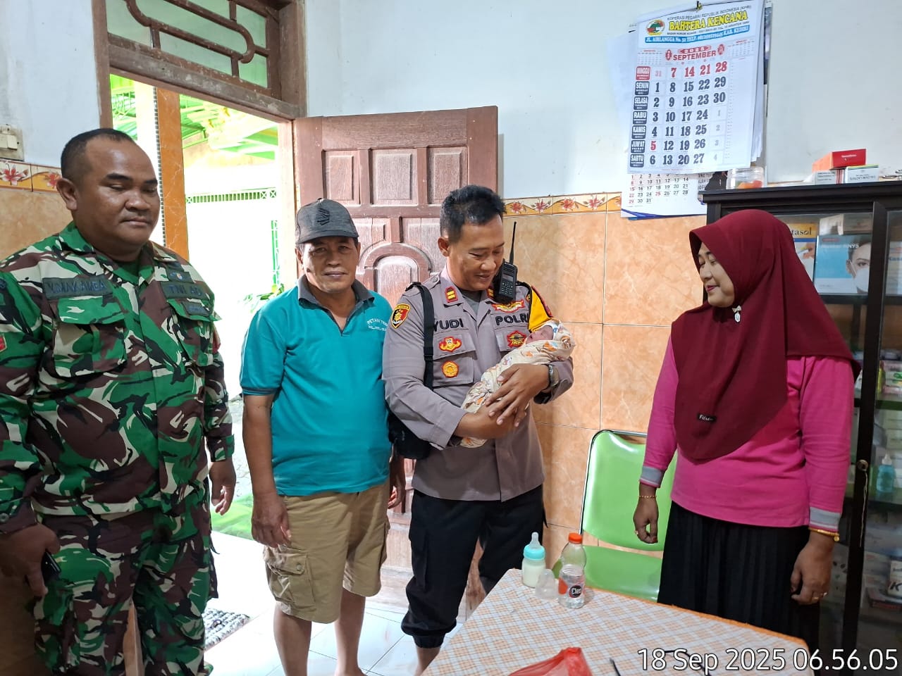 Kapolsek Gurah menggendong bayi yang dibuang orang tuanya.