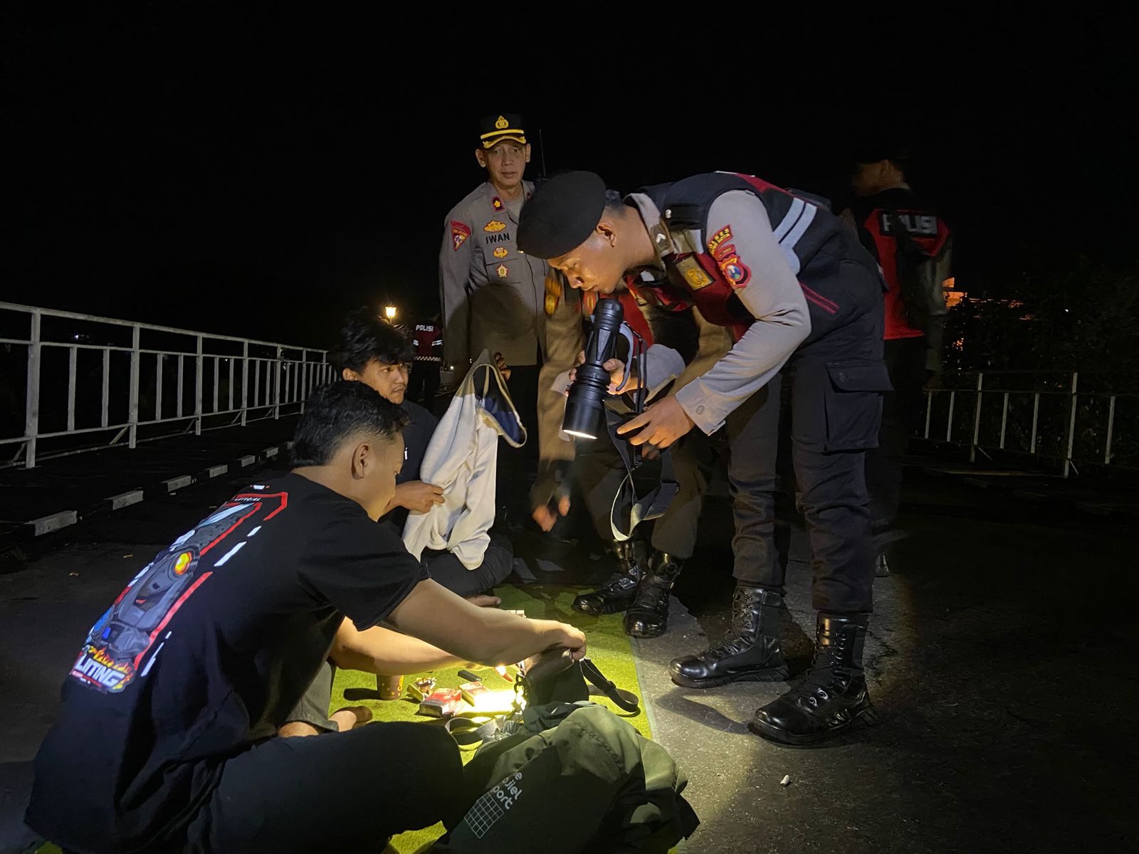 RAZIA: Petugas kepolisian memeriksa pemuda yang nongkrong di jembatan lama Kota Kediri.