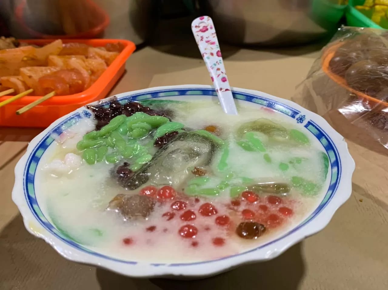 Semangkuk es dawet segar dengan isian cendol, mutiara, dan kacang hijau tersaji dengan kuah santan manis.