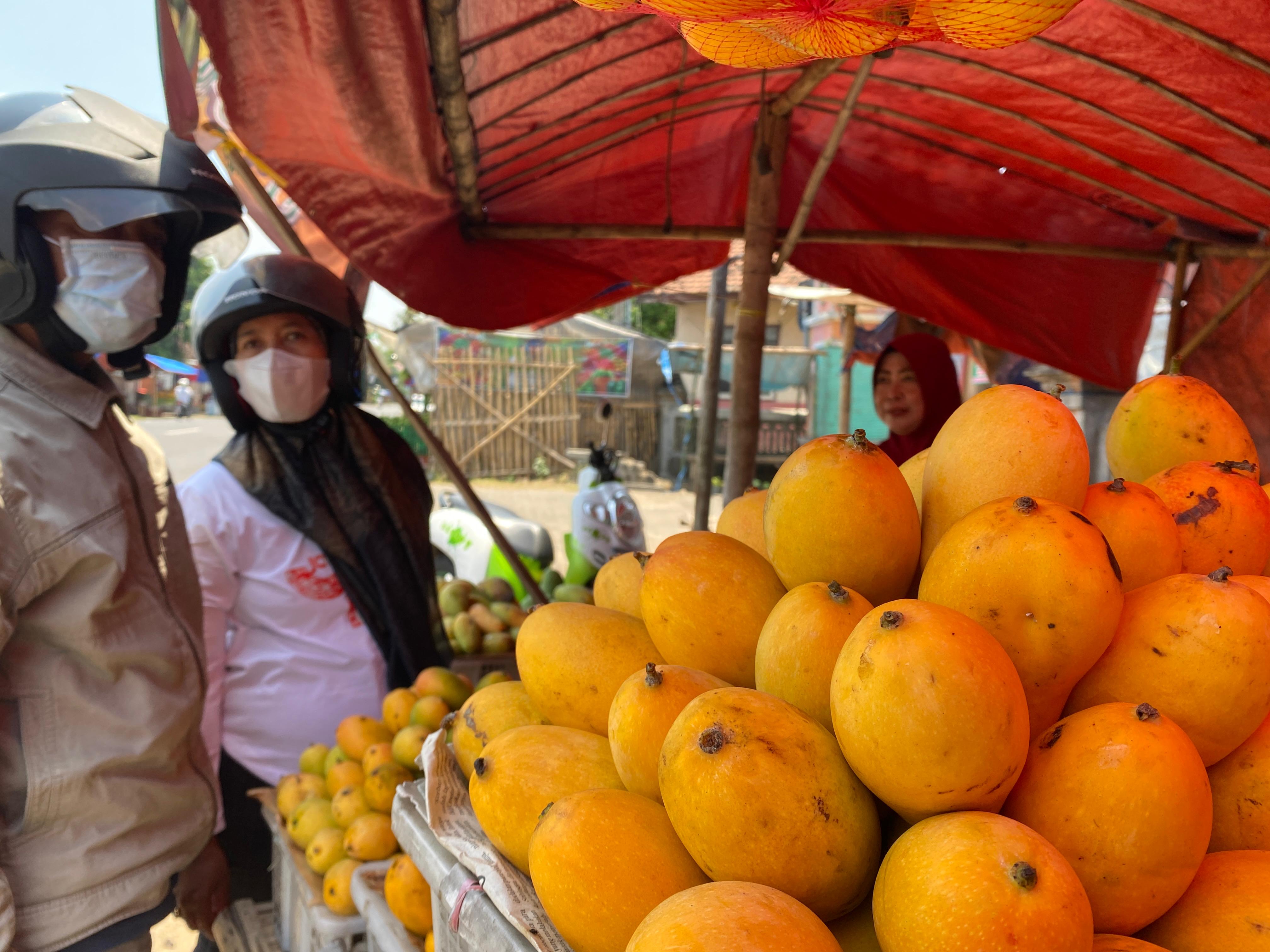 Ana menjajakan mangga di lapaknya.