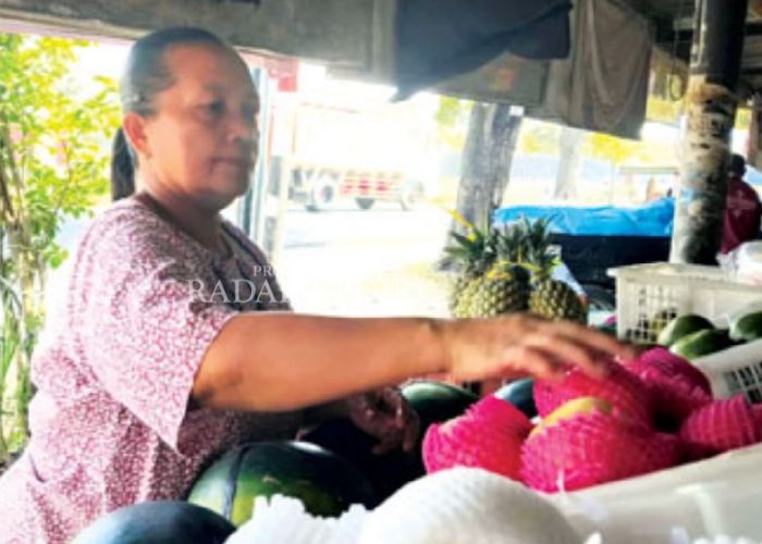 MELONJAK: Pedagang buah menata jualannya.
