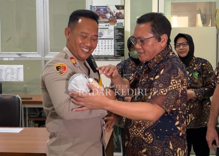 SEHAT: Kapolsek Gurah Iptu Ardian Wahyudi menggendong bayi laki-laki bersama Direktur RS Bhayangkara Kombes Pol. drg. Agung Hadi Wijanarko.