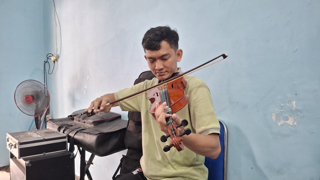Pandu Laksono,s seorang disabilitas netra, memainkan biola,