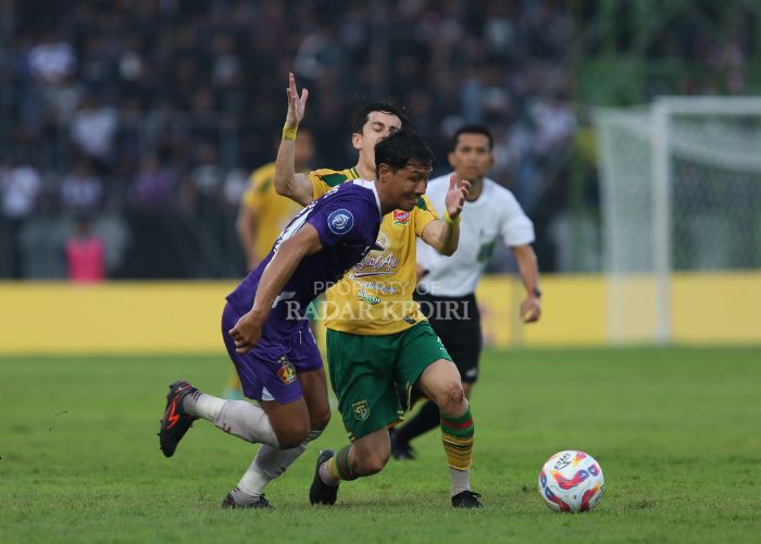 DERBY JATIM: Ady Eko berduel dengan pemain Persebaya saat laga di Stadion Brawijaya pada musim lalu.