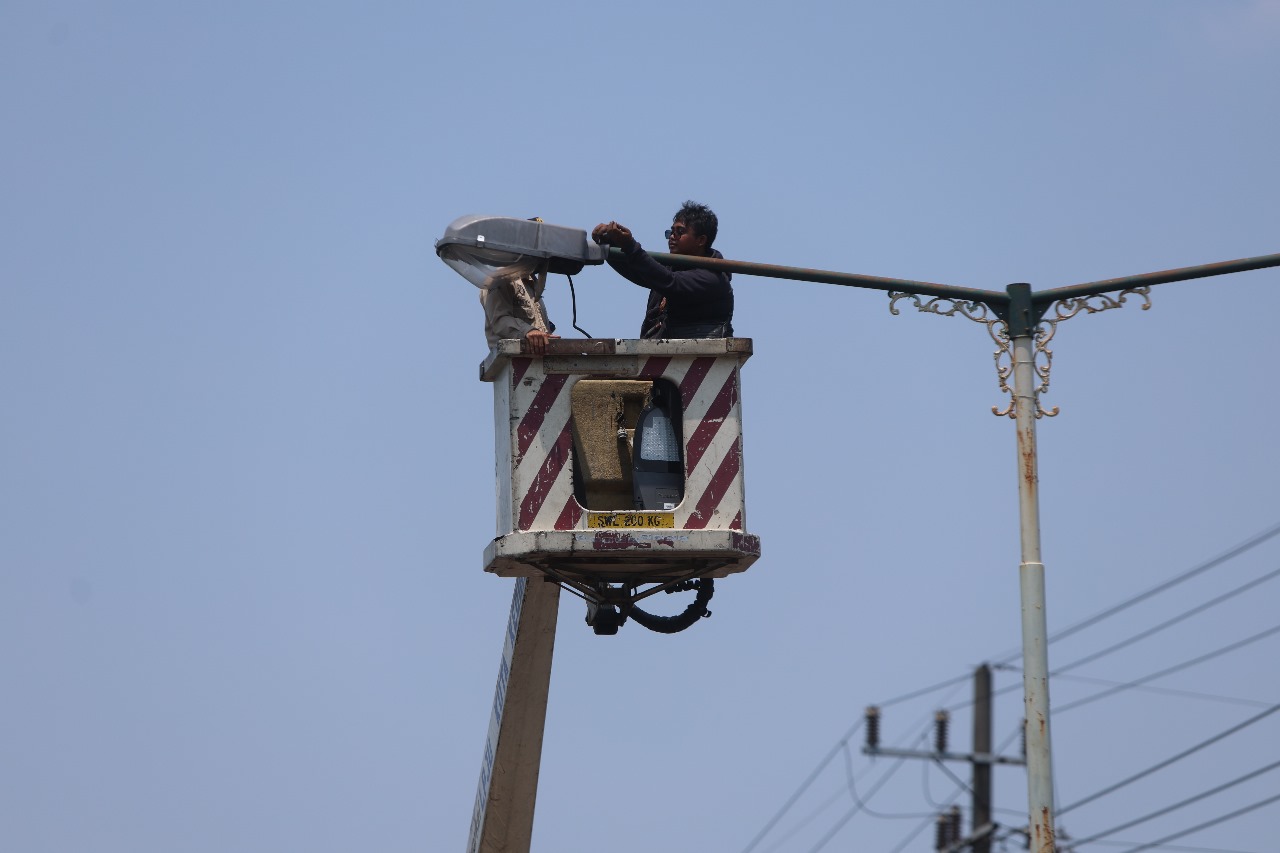 Petugas Dinas Perhubungan Kota Kediri mengganti lampu penerangan jalan umum di Jl Ahmad Yani menggunakan mobil sky lift.