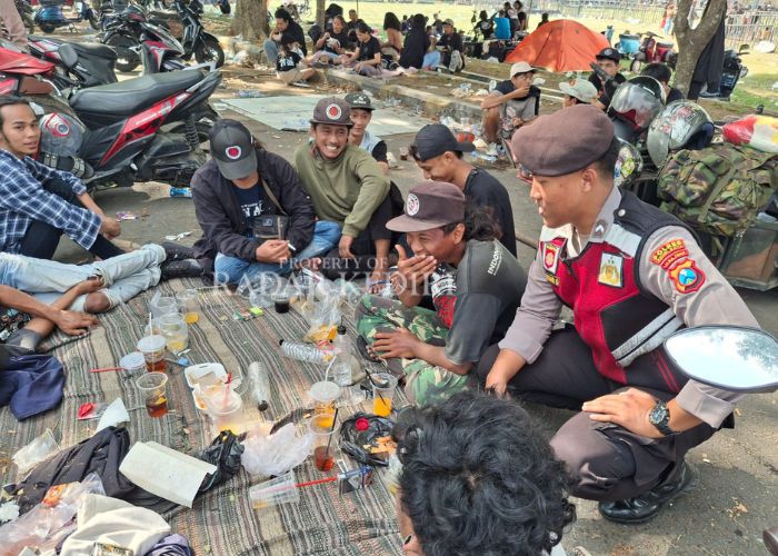 SWEEPING MIRAS: Anggota Samapta Polres Kediri Kota berbincang dengan peserta event skuter.