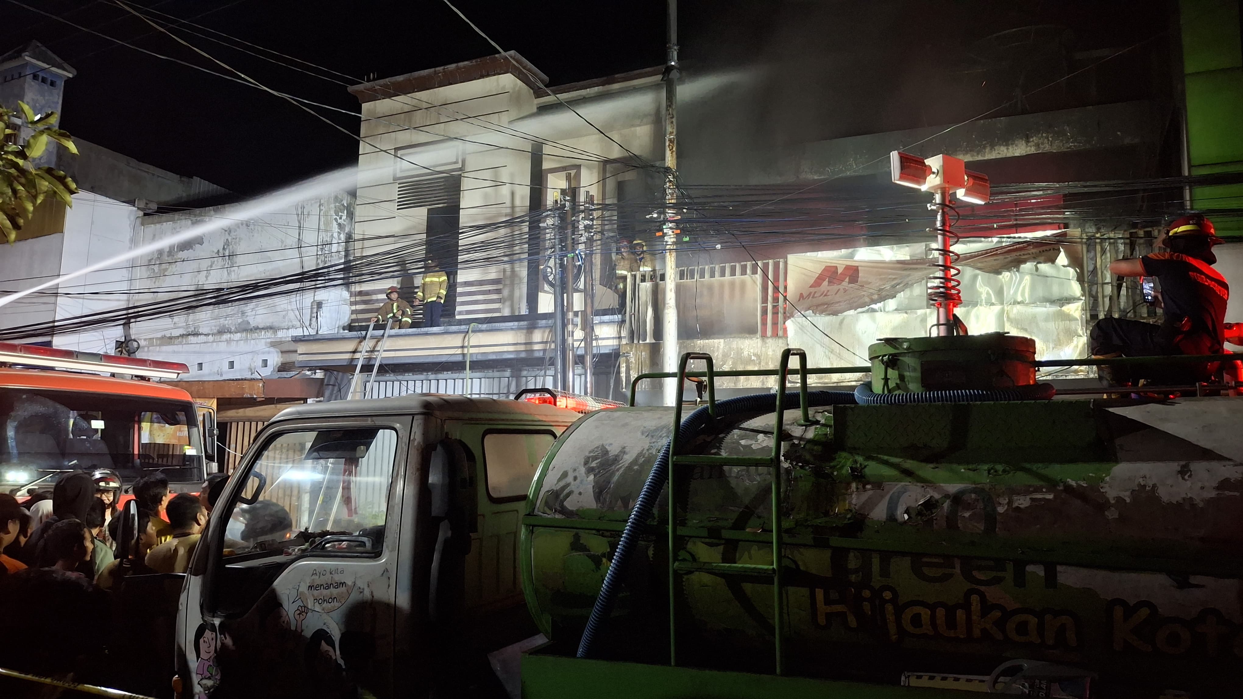 PANTANG PULANG SEBELUM PADAM: Petugas damkar berupaya menjinakkan api yang berkobar di toko perabotan di Jalan Dhoho Kediri.