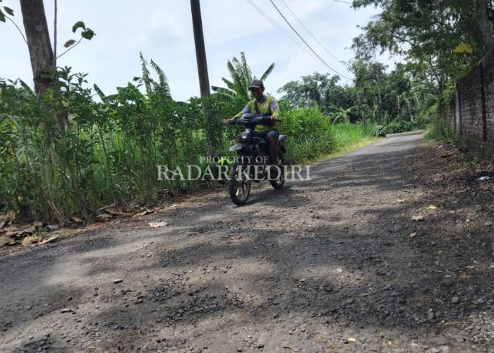 RUSAK: Warga melintas di jalan Desa Mayaran, Kecamatan Banyakan, Kediri yang kondisinya bergelombang.
