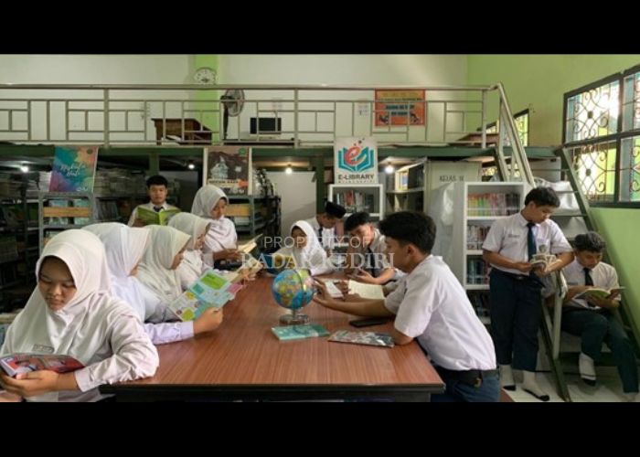 Suasana pojok literasi MTsN 5 Kediri, Jumat (4/10). Siswa-siswi tampak menikmati waktu membaca di E-Library madrasah.
