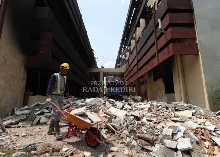 TAHAP AWAL: Pekerja mengangkut material pembongkaran Gedung Bupati dan Sekda Kediri.
