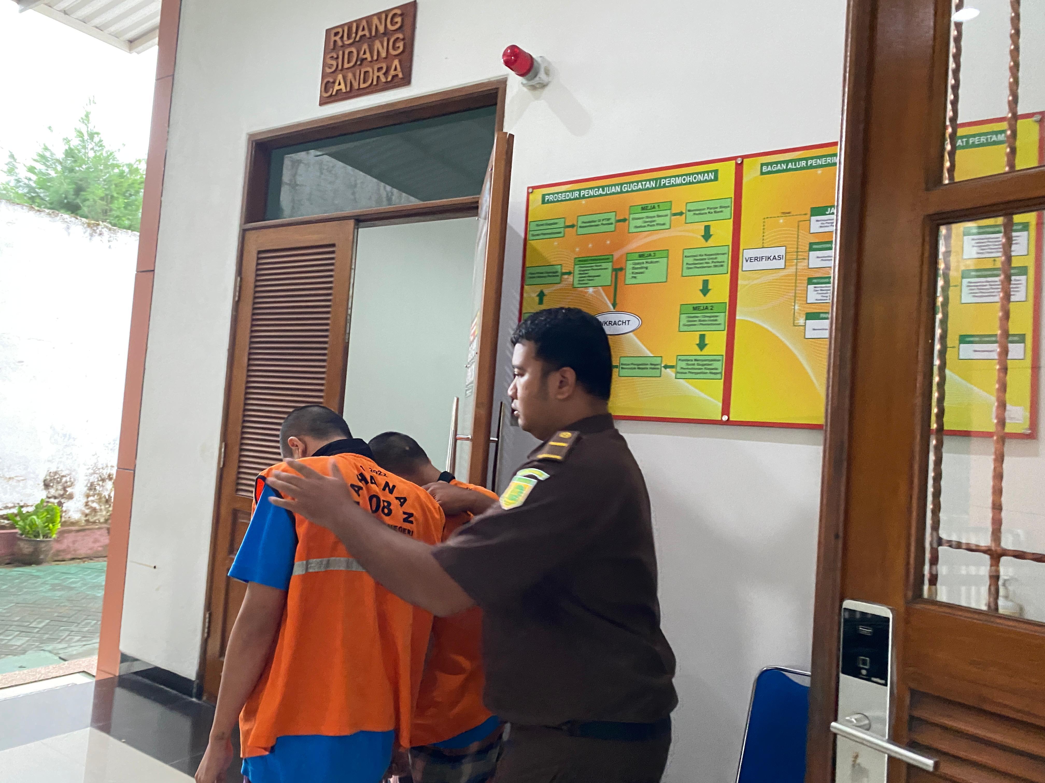 PESAKITAN: Terdakwa SFK dan MRT digelandang keluar ruang sidang di PN Kota Kediri.  &nbsp;