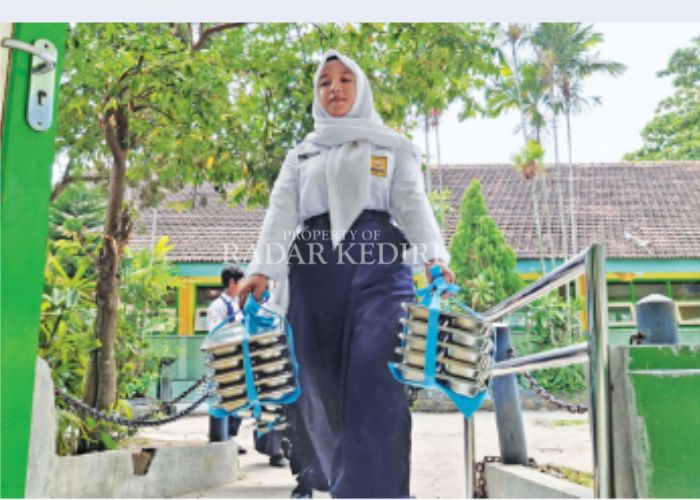 MBG: Seorang siswa membawa ompreng tempat makan bergizi gratis.