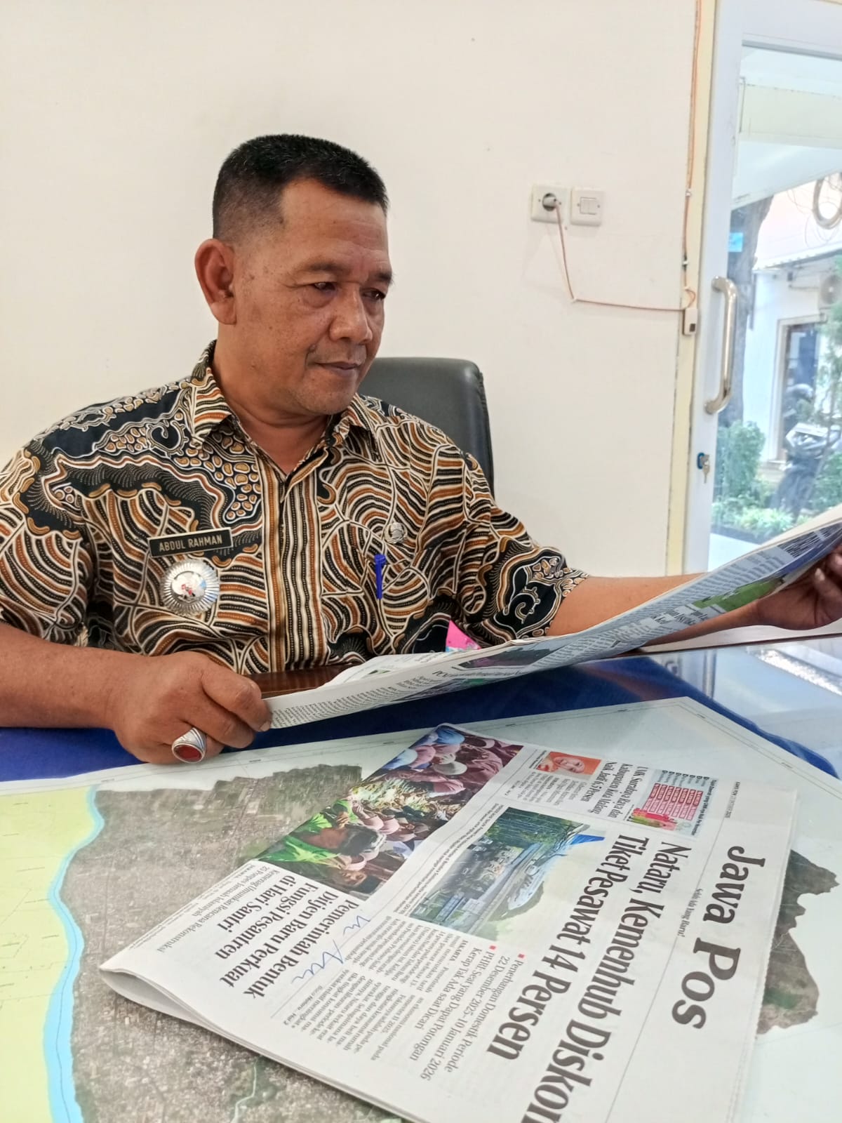 MENGAYOMI: Sosok Camat Mojoroto Abdul Rahman saat membaca koran Jawa Pos Radar Kediri.