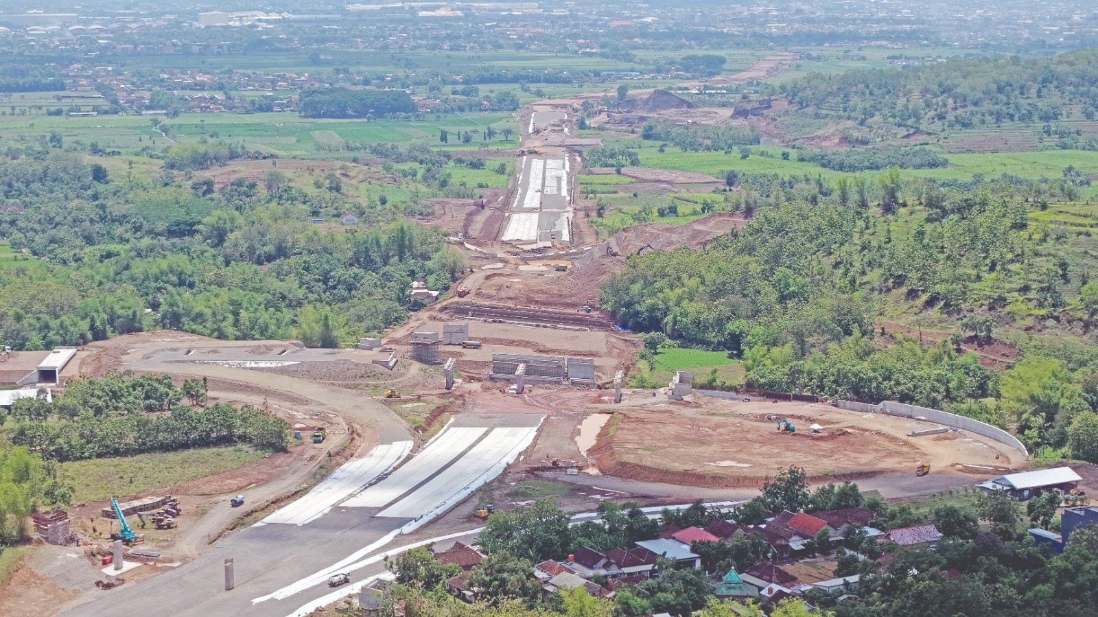Sejumlah pekerja merealisasikan pembangunan tol akses bandara di Desa Tiron, Banyakan. Di saat yang sama pemkab masih menuntaskan aset mereka yang terdampak proyek.