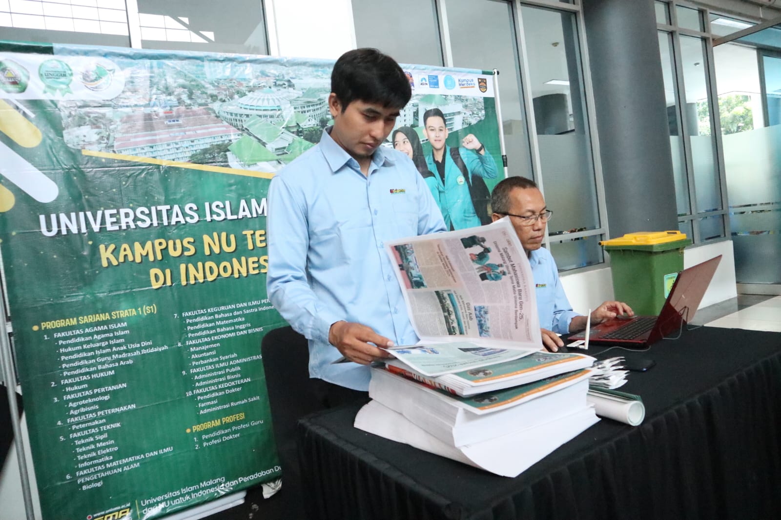 THE BEST: Staf Unisma Malang merapikan koran kampus yang dibagikan saat school contest.
