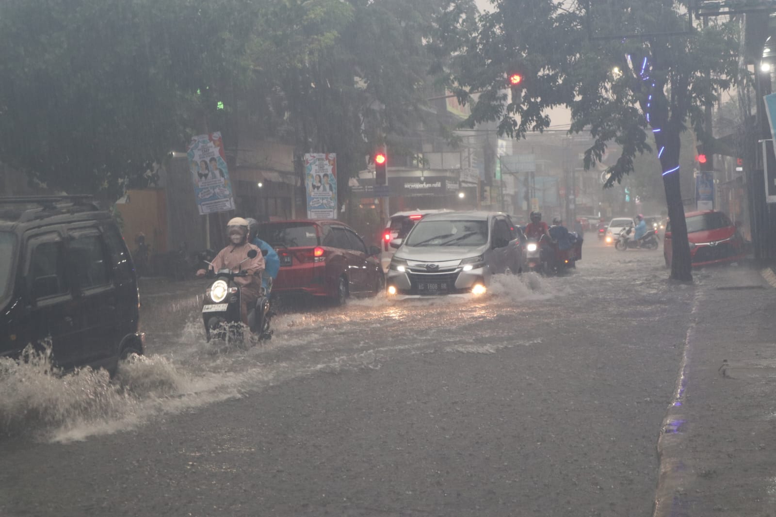 DIGUYUR HUJAN: Kendaraan menerjang banjir di jalan protokol Kota Kediri.