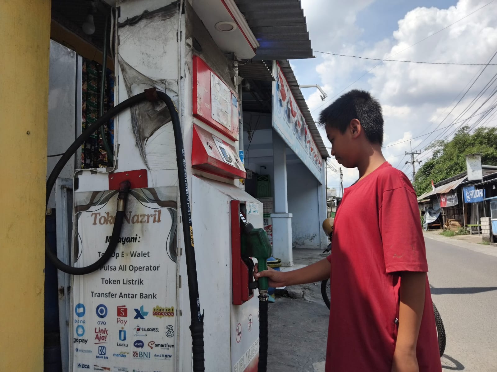 SERET: Penjual di pom mini menunggu pelanggan.