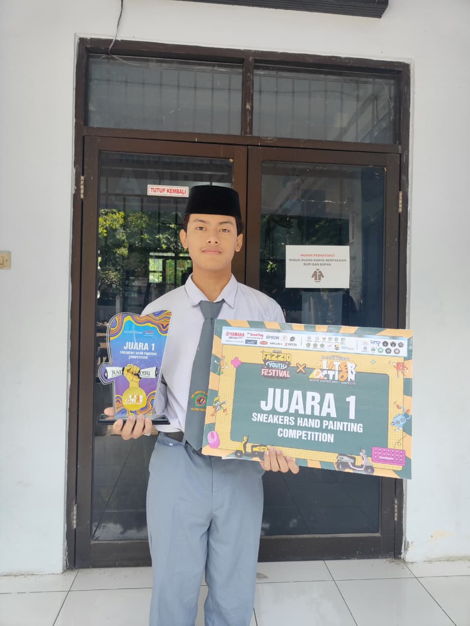BERBAKAT: Muhammad Fahmi Ibrahim menunjukkan trofi dan plakat usai memenangi ajang Sneakers Hand Painting di School Contest GenZverse 2025.
