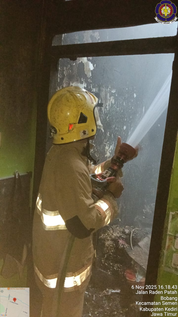 Petugas memadamkan api di rumah warga Semen Kediri.