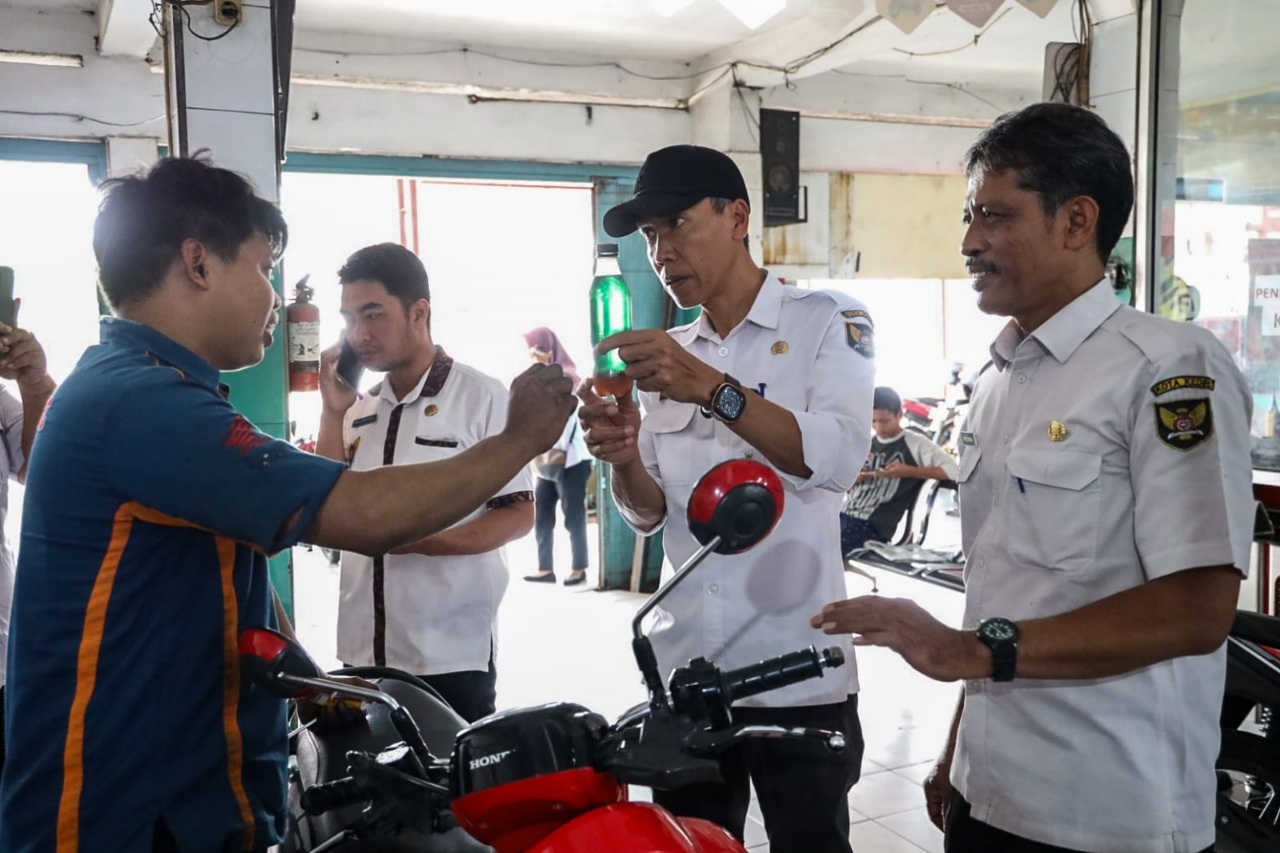 Petugas dari Disperdagin Kota Kediri berbincang dengan pemilik bengkel servis motor Rabu (5/11).