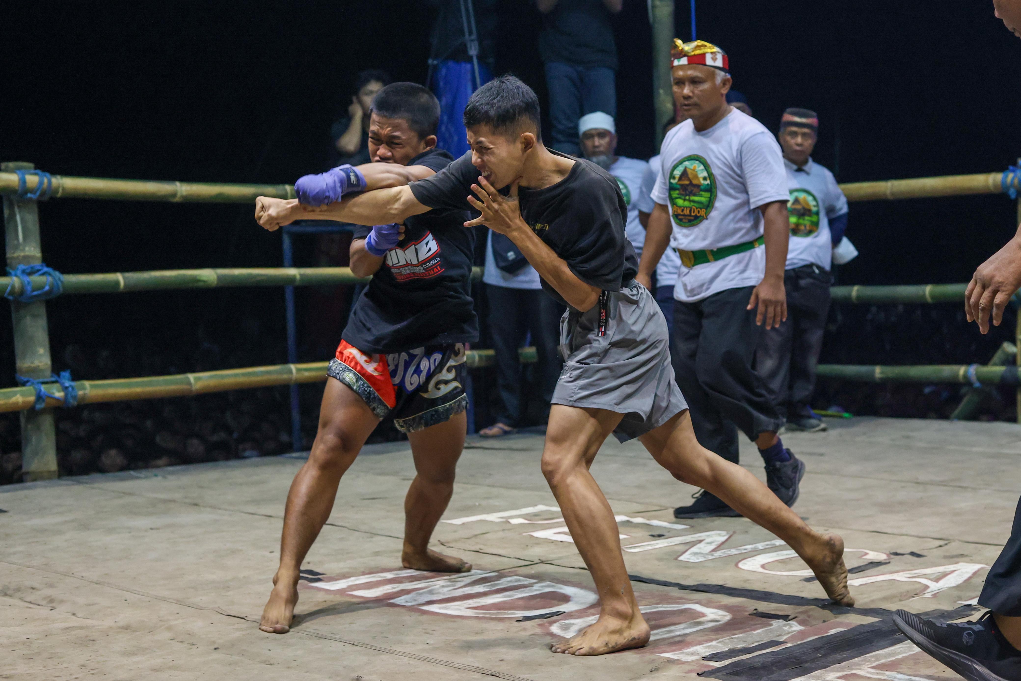 Pesilat bertarung dalam ajang Pencak Dor di Omah Sawah Kota Kediri.