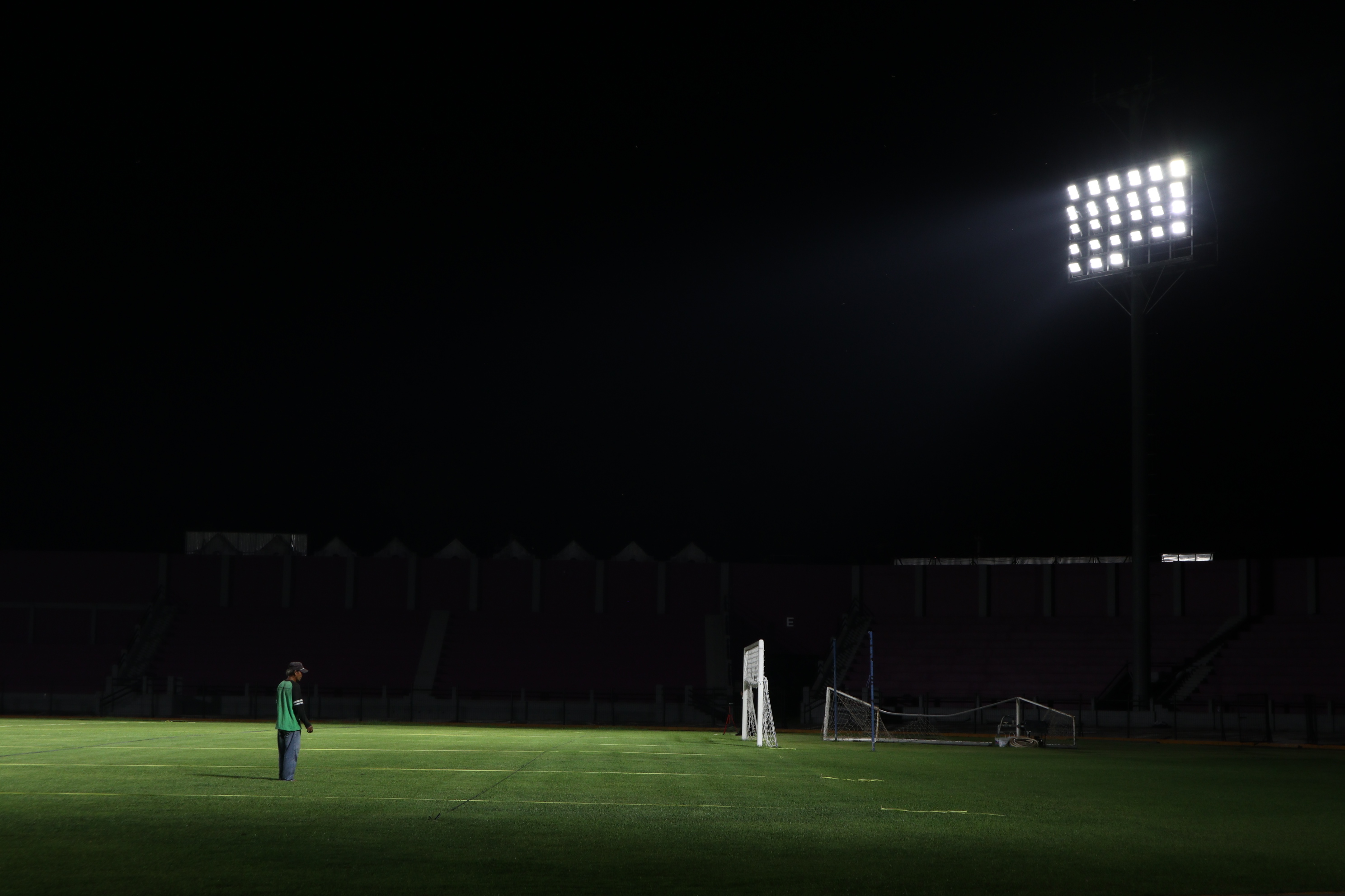 Seorang pekerja memeriksa rumput lapangan di Stadion Brawijaya Kediri.