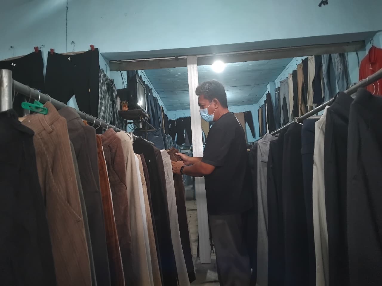 Seorang pembeli sedang memilih celana di Pasar Gombek Gringging Kecamatan Grogol, Kabupaten Kediri.