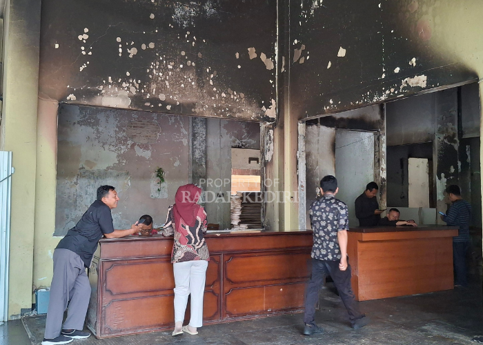 DARURAT: Staf Sekretariat DPRD Kabupaten Kediri beraktivitas di gedung dengan dinding berjelaga sisa insiden pembakaran oleh massa pada akhir Agustus lalu.  &nbsp;