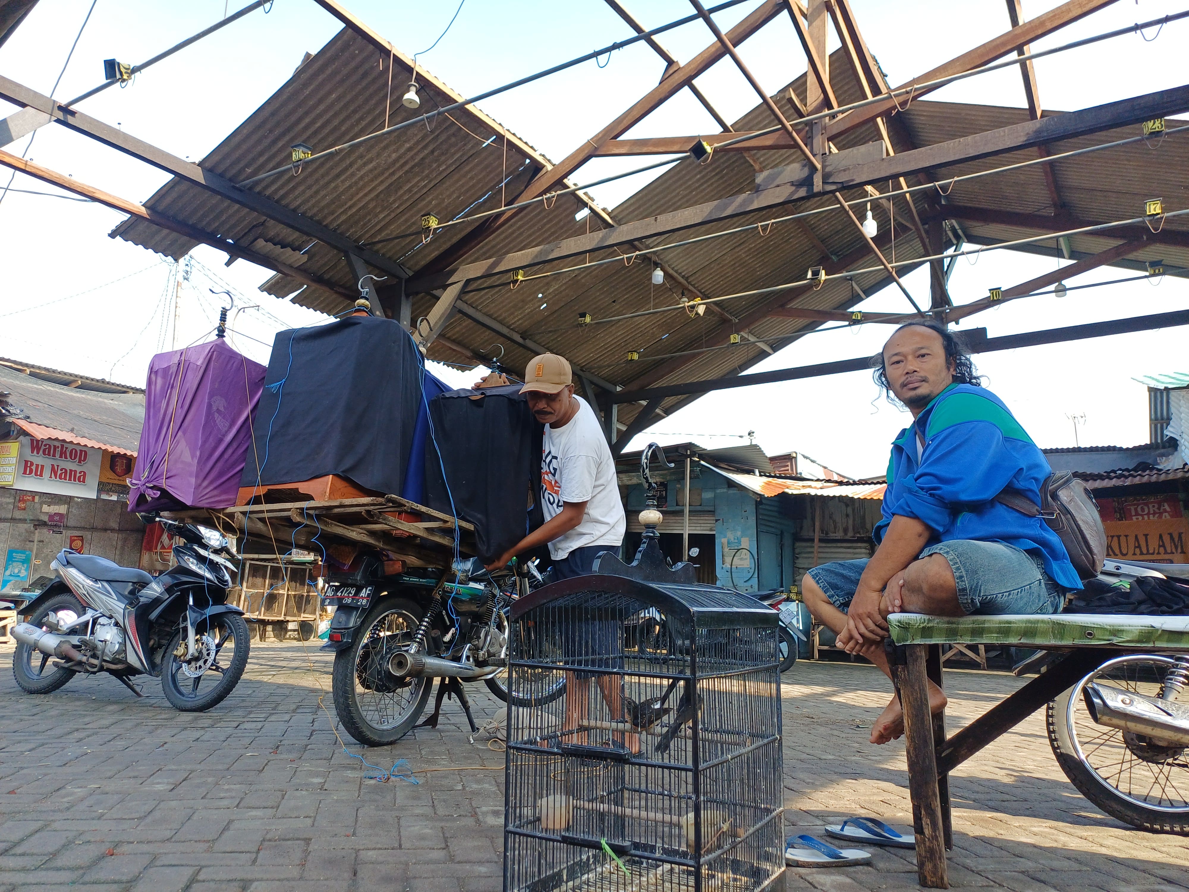 BERATAP LANGIT: Sejumlah pedagang burung tetap beraktivitas di Pasar Burung Setonobetek meski atap lapak jebol tersapu angin kencang pada Kamis (20/11) siang.