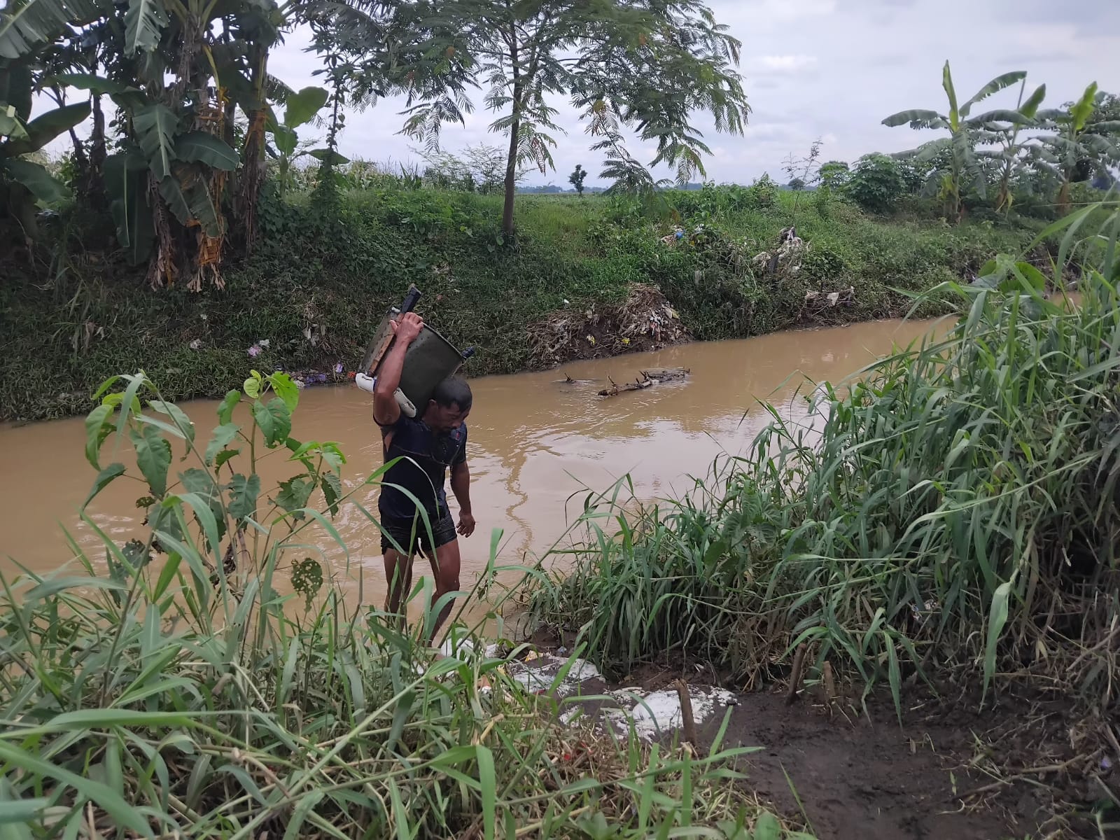 KERAP BANJIR: Seorang warga mengangkat pasir dari Sungai Hadisingat.