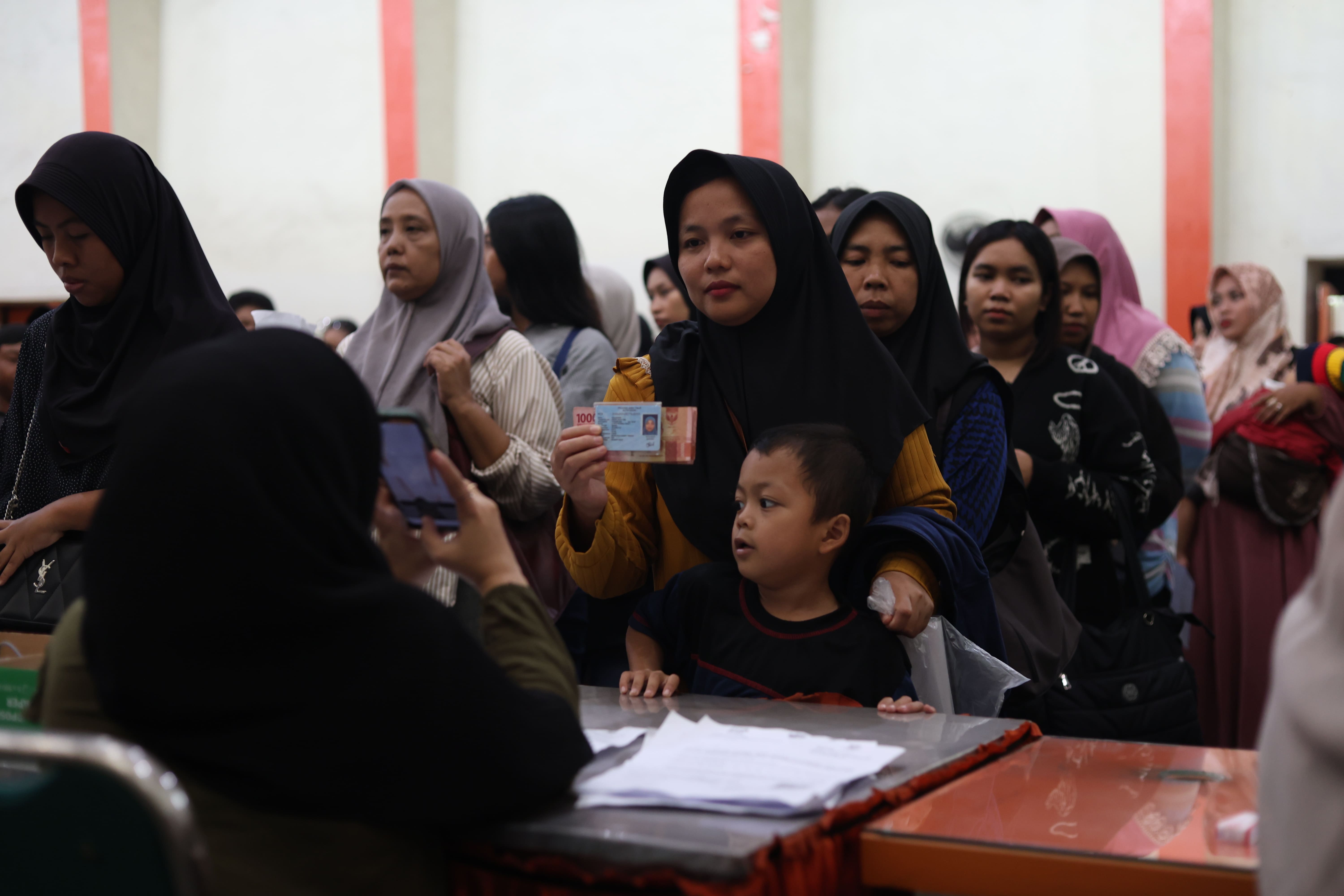 REKAM BUKTI: Petugas Kantor Pos Kediri memotret Kartu Tanda Penduduk warga yang mencairkan BLTS. Hingga kemarin antrean ribuan warga memenuhi halaman kantor pos sejak pagi.