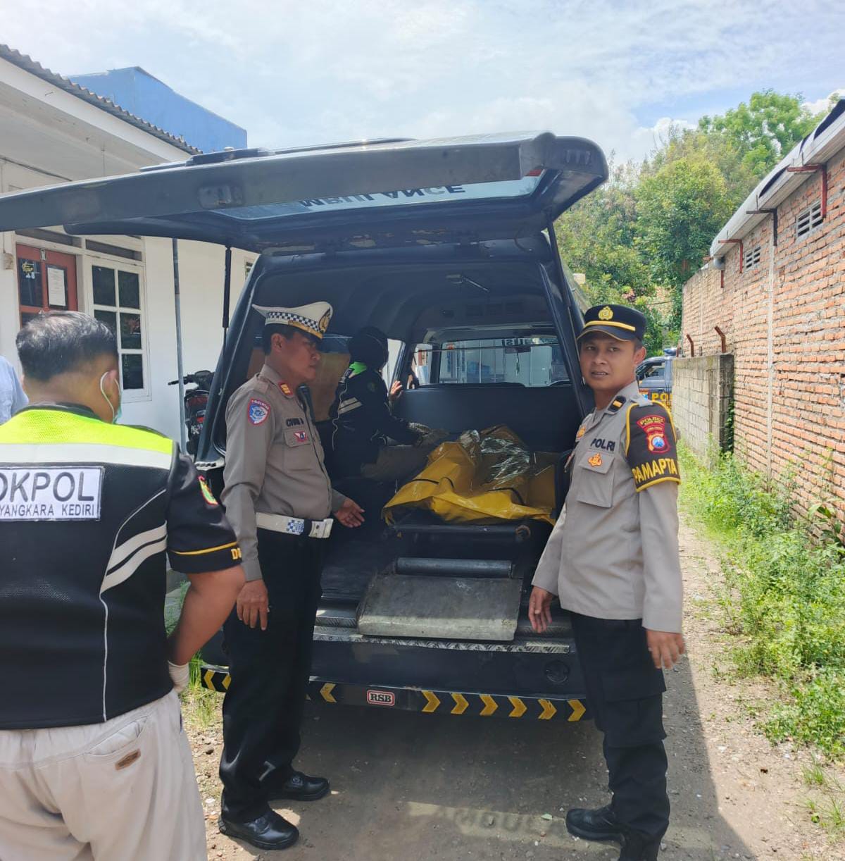 BIKIN GEMPAR: Polisi memasukkan jenazah korban di mobil RS Bhayangkara.