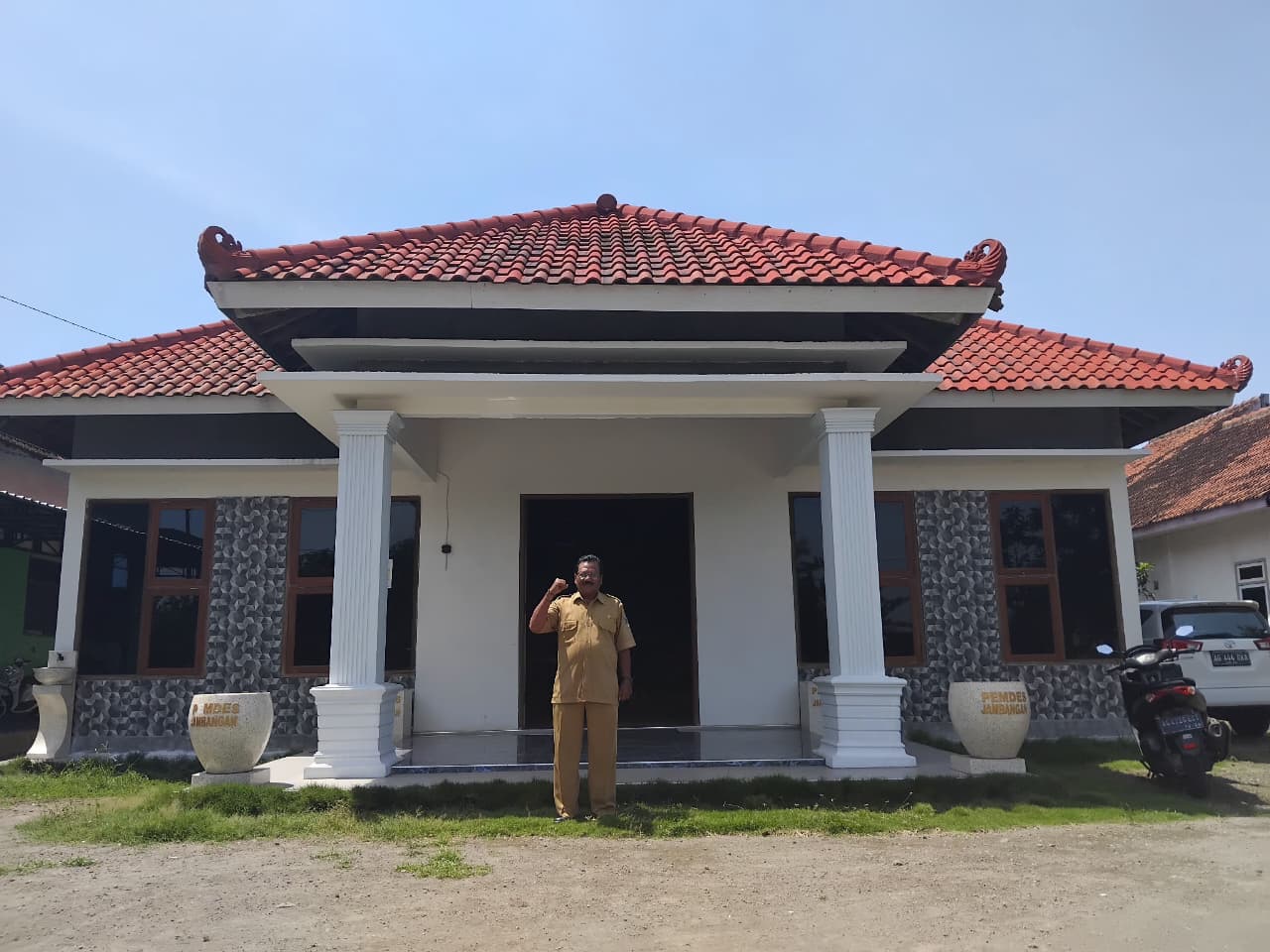 Kepala Desa Jambangan berpose di depan kantor baru (Diana Yunita Sari)