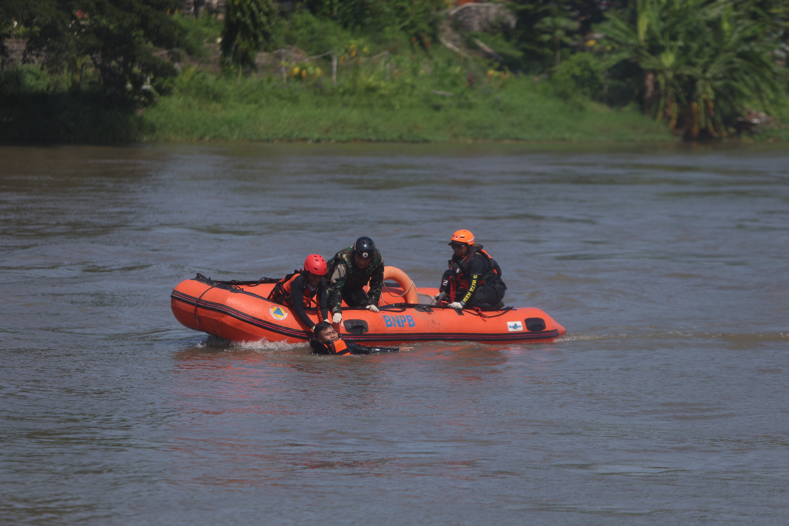 CEKATAN: Petugas BPBD Kota Kediri menyelamatkan korban tenggelam saat simulasi banjir di Sungai Brantas.