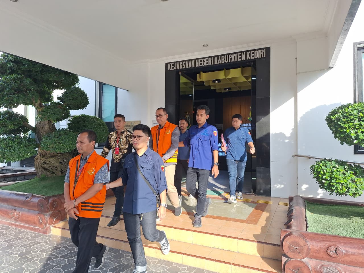 Kades Pojok Darwanto (rompi oranye depan) dan Kades Kalirong Imam Jamiin (rompi oranye belakang) digelandang menuju ke mobil tahanan dalam pelimpahan tahap 2 di Kejari Kabupaten Kediri (28/11).