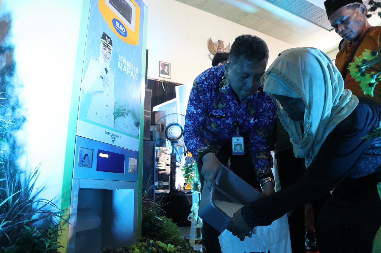 Warga antre mencairkan beras bansos lewat mesin ATM di Kelurahan Semampir. Total ada 46 ATM beras yang dioperasionalkan mulai Senin (1/12).