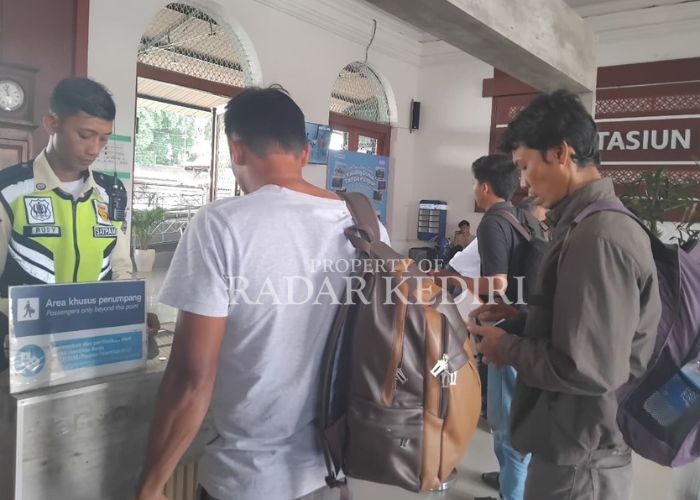 ANTRE: Petugas mengecek tiket KA di Stasiun Kediri.