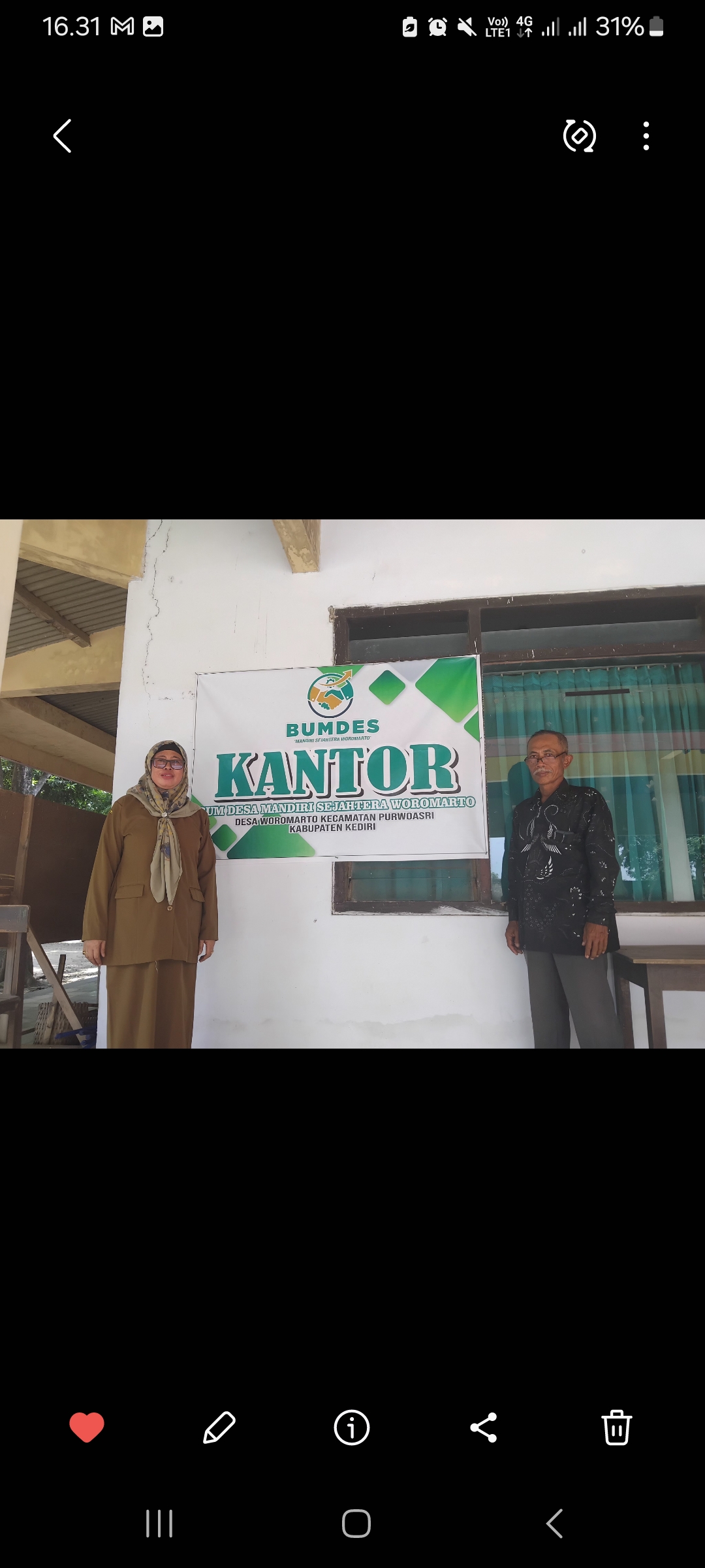 Kepala Desa Woromarto berfoto di depan kantor Bumdes (Diana Yunita Sari)