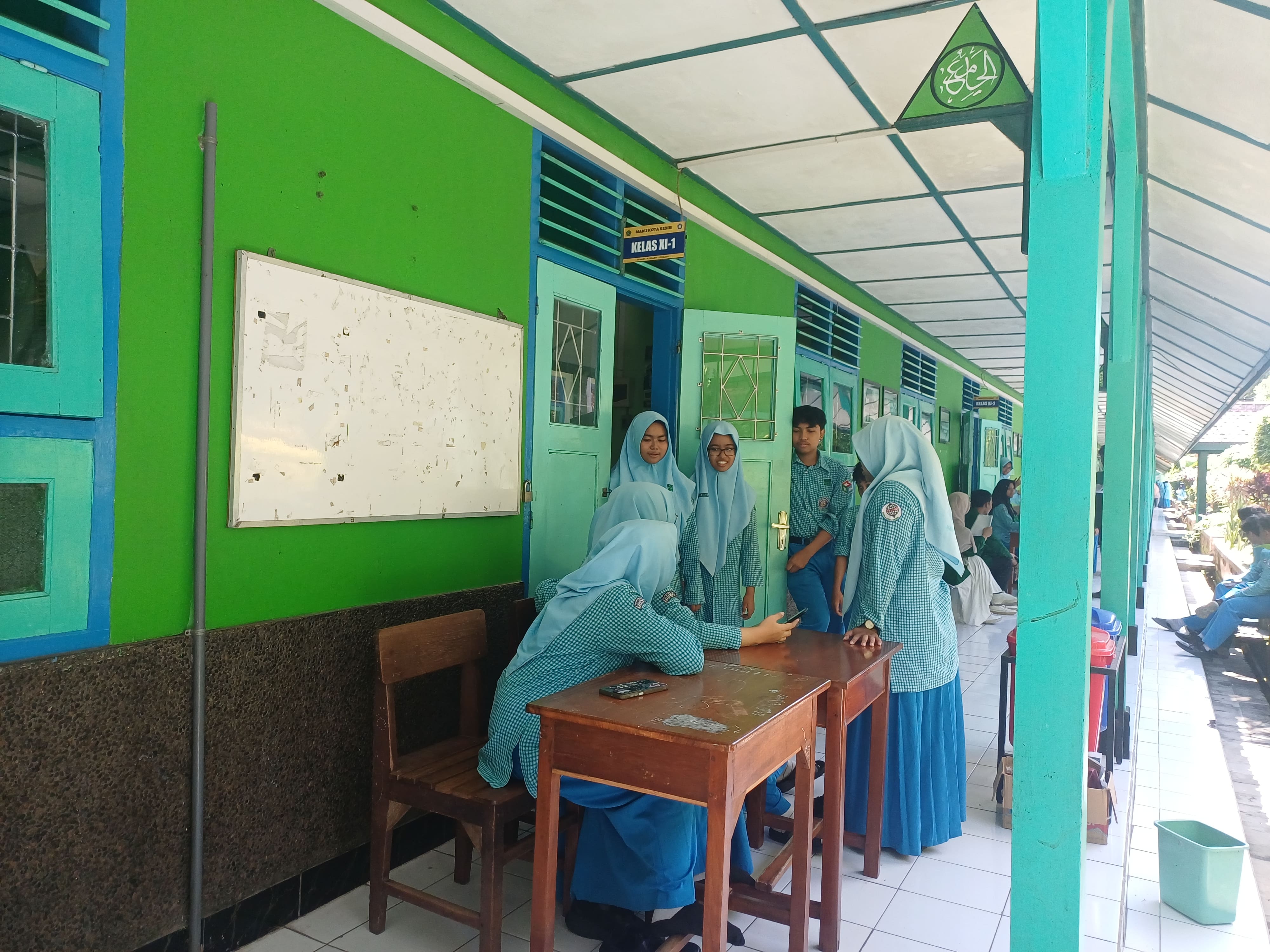 TAK ADA OMPRENG: Deretan meja yang biasanya jadi tempat transit ompreng MBG sejak kemarin kosong karena MBG di MAN 2 Kota Kediri dihentikan sementara.