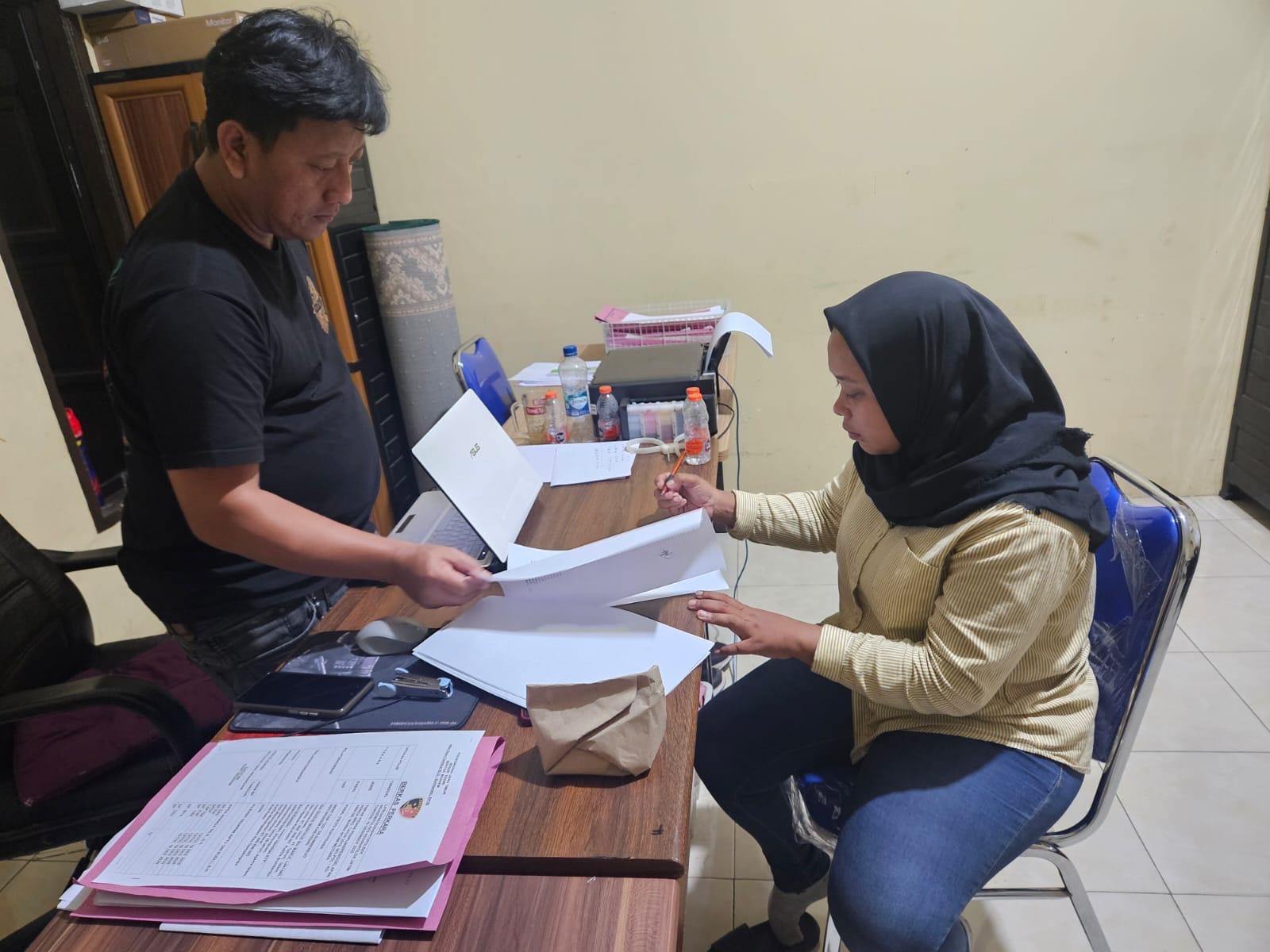 Petugas menginterogasi tersangka.