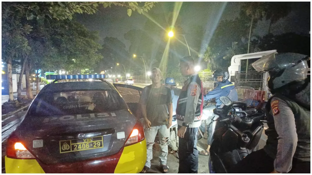 Polisi saat mengamankan juru parkir yang hendak melakukan aksi pemukulan