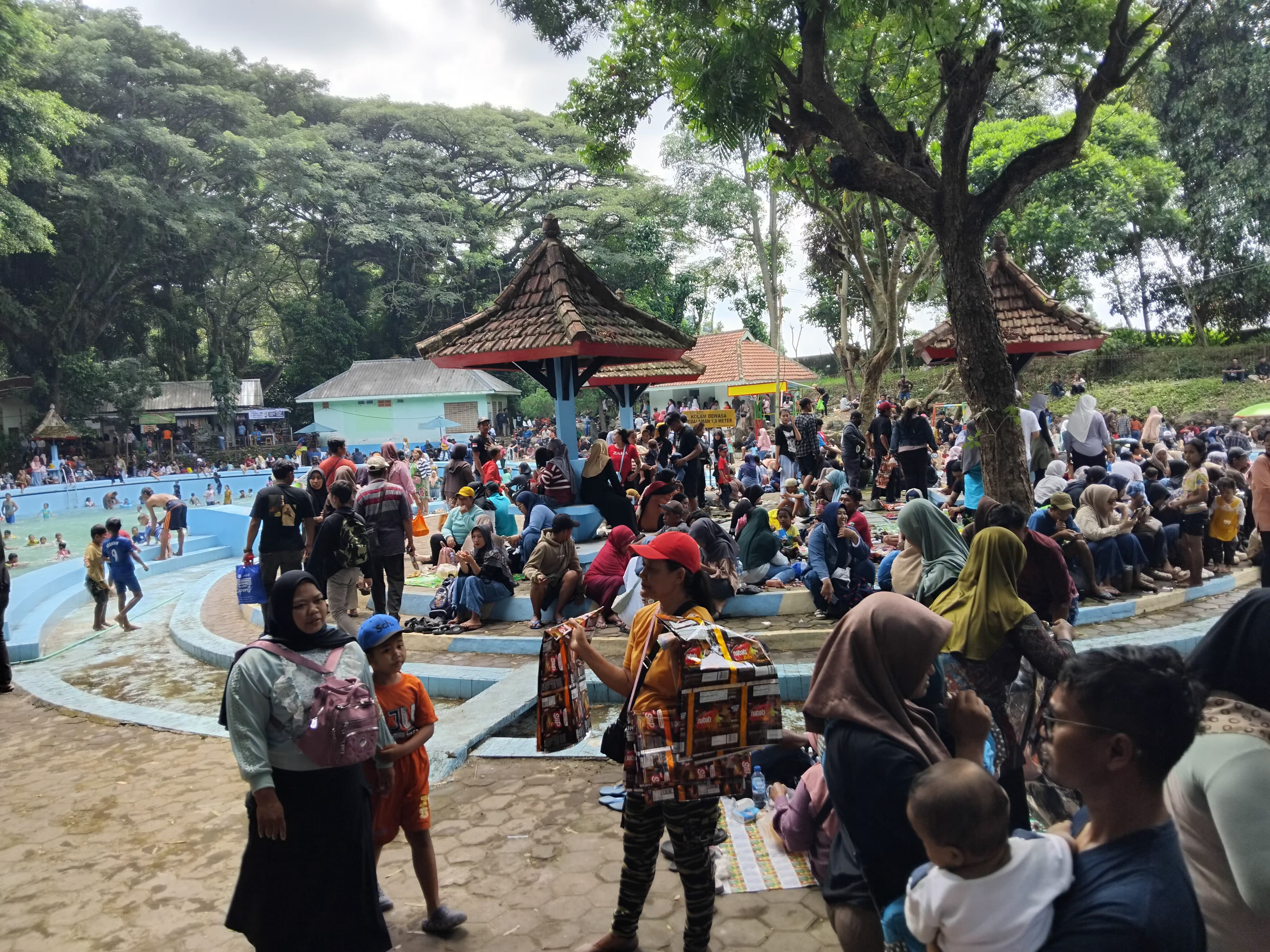 MEMBLUDAK: Pengunjung memadati wisata Sumber Ubalan di Plosoklaten saat libur Nataru.