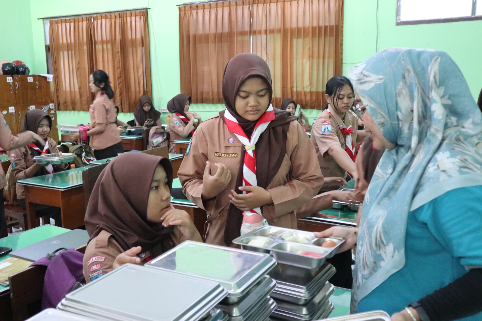 Guru SMAN 7 Kediri mengawasi pembagian paket makan bergizi gratis (MBG) Oktober 2025 lalu. Januari ini, siswa di Kota Kediri kembali menerima paket makanan baik dalam bentuk mentah maupun matang.