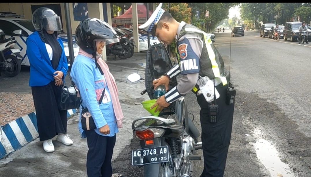 &lsquo;TUGAS&rsquo; TAMBAHAN: Aiptu Agung Broto membelikan BBM pengendara motor yang tangkinya kehabisan di tengah jalan.