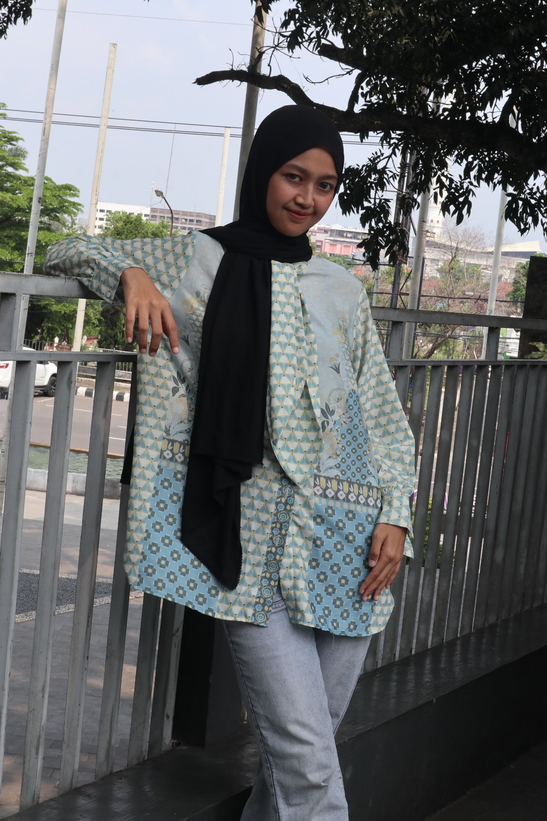 Perempuan sedang mengenakan pashmina instan. Terlihat lebih anggun dan modis.