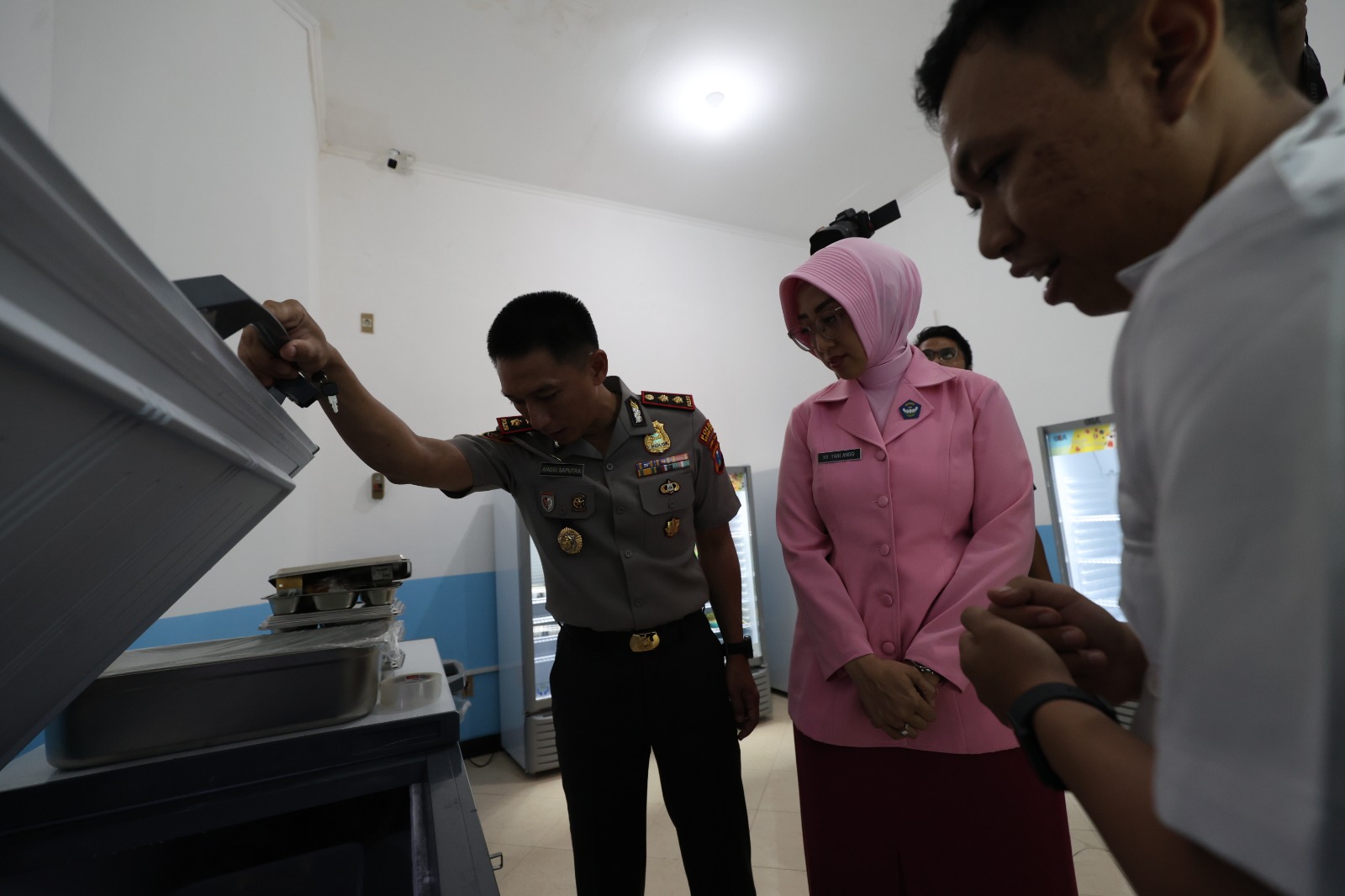 STOK AMAN: Kapolres Kediri Kota AKBP Anggi Saputra Ibrahim memeriksa stok bahan makan di freezer dalam peresmian SPPG Semampir 2 kemarin.