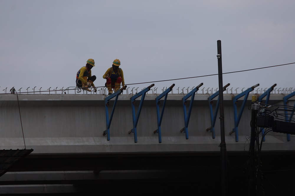 TERUS DIKEBUT: Pekerja proyek bekerja keras menyambungkan jalan layang di Kelurahan Mojoroto, Kota Kediri.&nbsp;