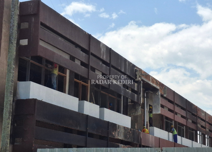 BANGUN ULANG: Sejumlah pekerja fokus melakukan perbaikan gedung Pemkab Kediri yang dibakar dan dirusak massa pada akhir Agustus 2025 lalu. Perbaikan ditarget selesai Juni lalu. (Foto: Asad M.S)