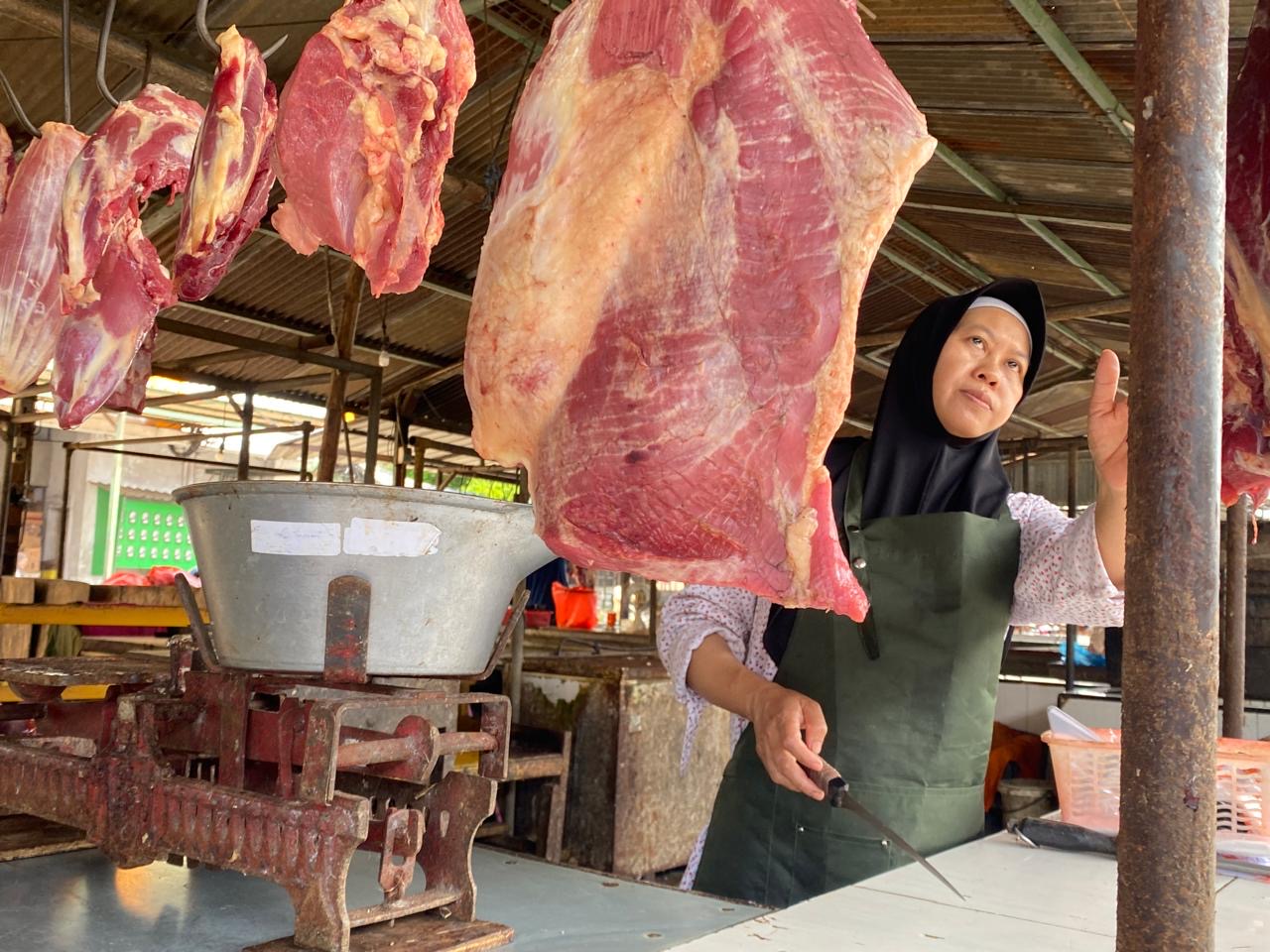 HARGA MERANGKAK NAIK: Siti Mazuroh, penjual daging sapi melayani pembeli di lapaknya. Satu kilogram daging dibanderol Rp 115 ribu.
