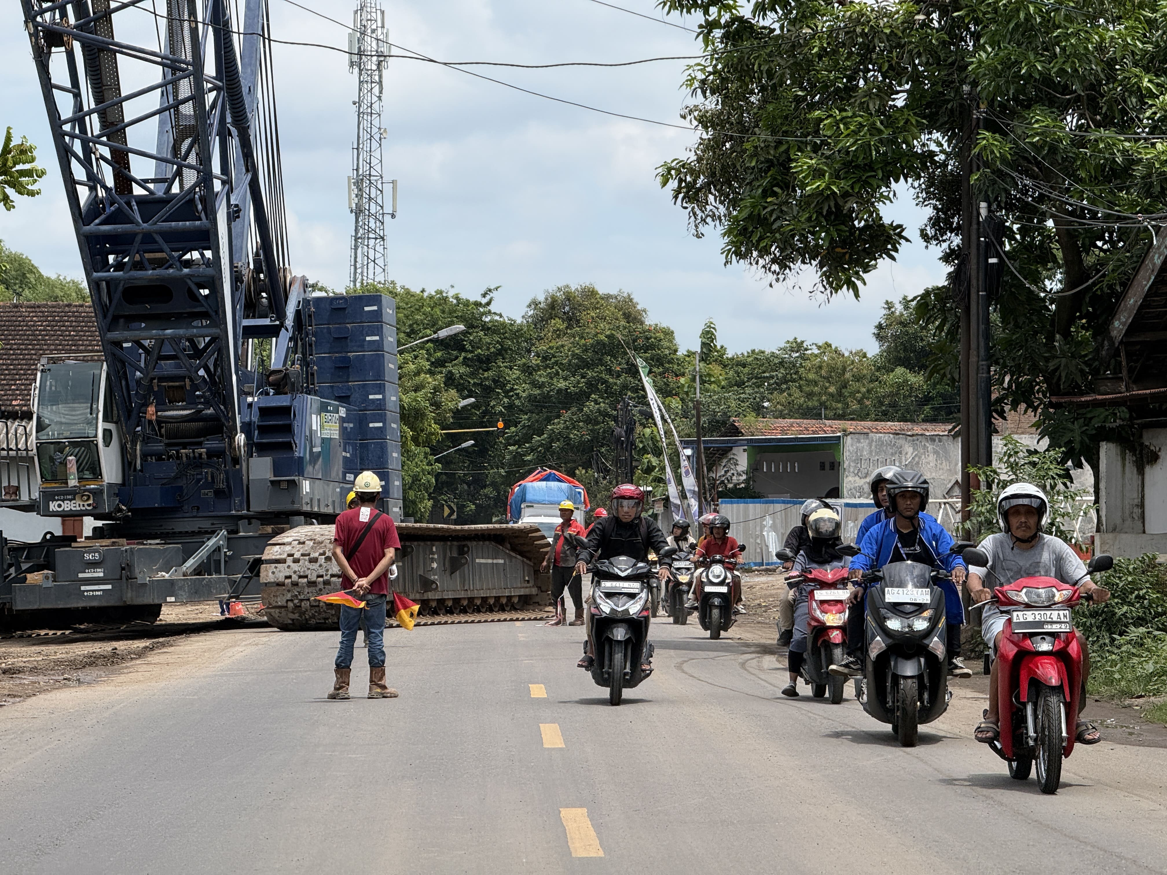 PROYEK BESAR: Pengendara melintas di depan papan pengumuman penutupan jalan Suparjan Mangunwijaya Kota Kediri.